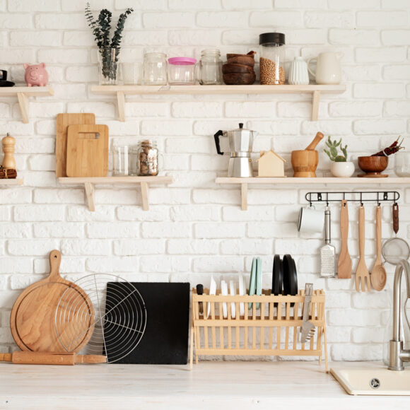 Rustic kitchen interior with white brick wall and white wooden shelves